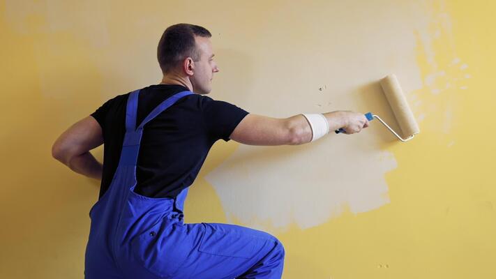 painter-man-with-a-roller-brush-builder-at-work-painting-wall-makeover-and-renovation-indoors-professional-painting-services-video